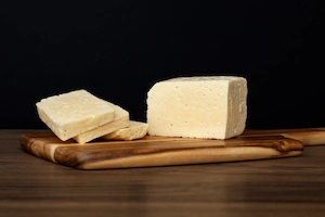 Tabla con trozos de queso curado para acompañar vino tinto
